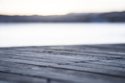 Close-up of pier over lake against sky