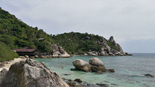 Rocks by sea against sky