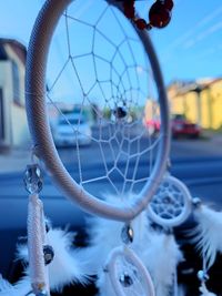 Close-up of dreamcatcher hanging in car