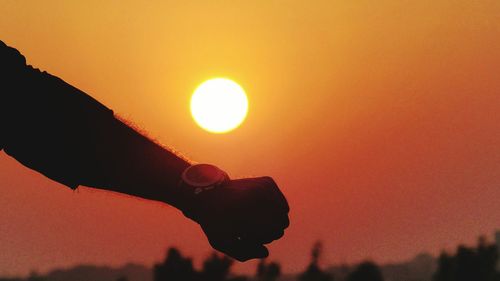 Silhouette man against orange sky during sunset