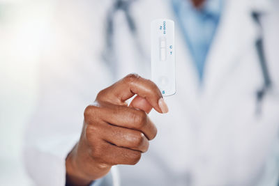 Midsection of businessman holding test tube