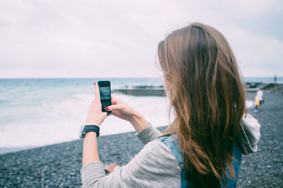 Woman photographing at beach