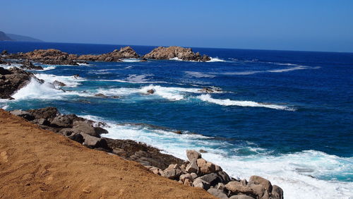 Scenic view of sea against clear blue sky