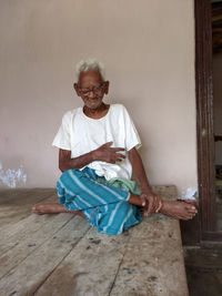 Portrait of woman sitting on wall