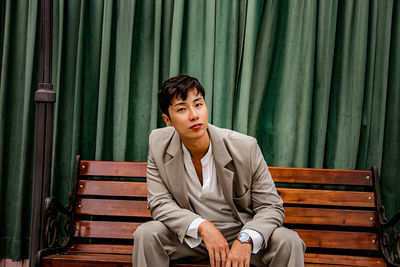 Young man sitting on bench in park