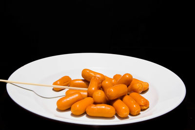 Close-up of food in plate against black background