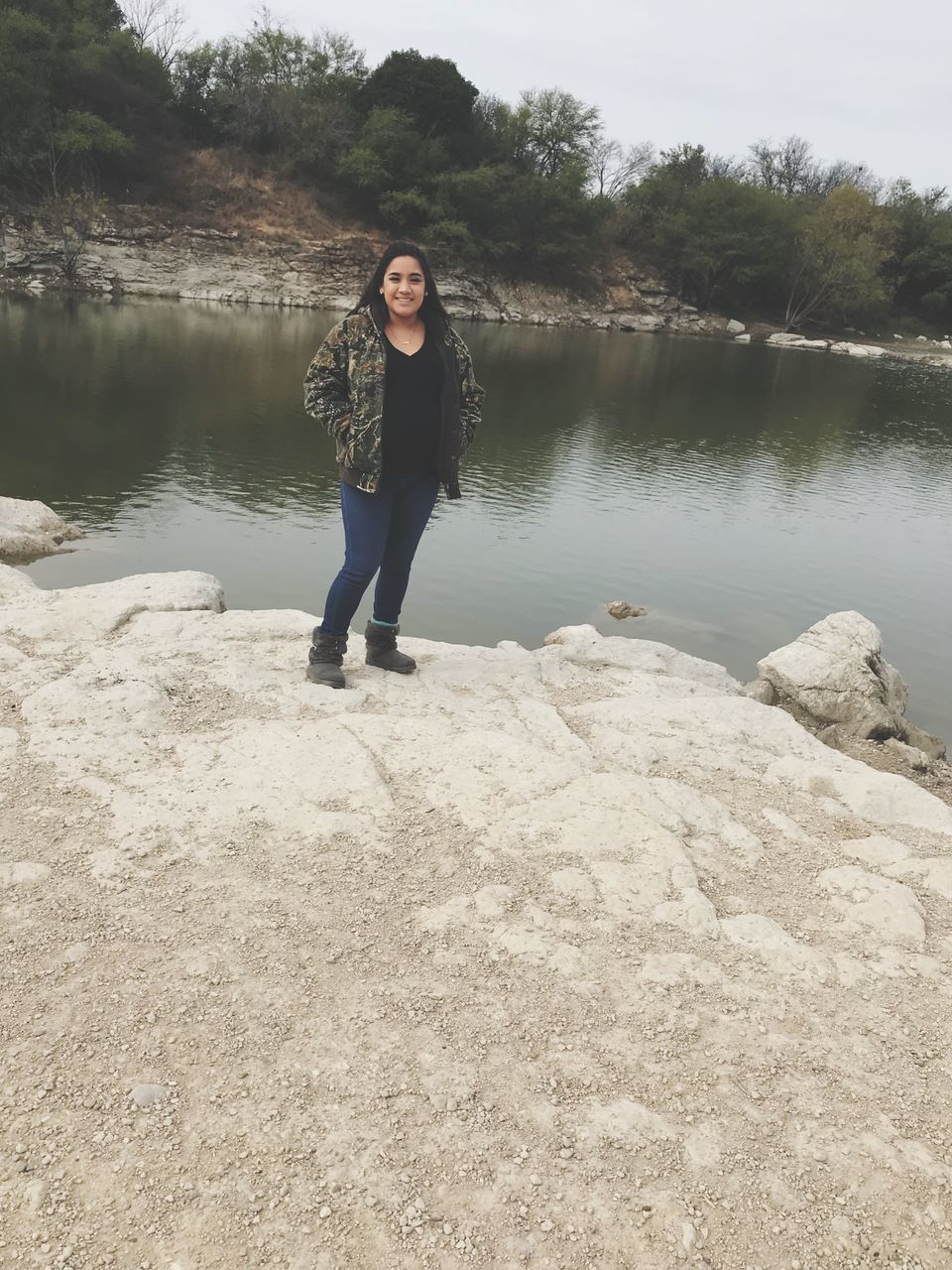 water, full length, front view, real people, one person, young women, looking at camera, leisure activity, young adult, lake, nature, outdoors, casual clothing, standing, day, lifestyles, portrait, tree, beauty in nature, beautiful woman, sky