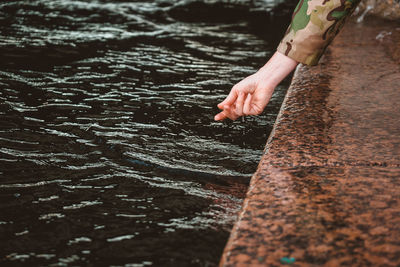 The girl's wet hand contact the water. touching the river with the palm of your hand while walking 