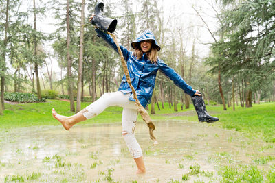 Full length of woman enjoying in puddle at park