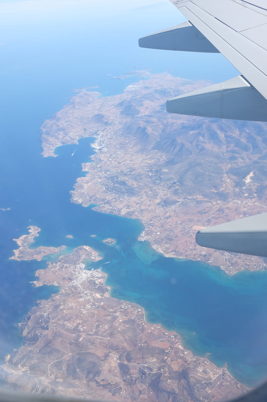 AERIAL VIEW OF AIRPLANE WING ABOVE LANDSCAPE