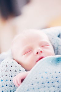 Close-up of baby lying on bed