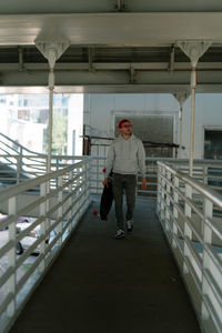 Full length of man walking by railing
