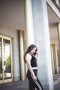 Young woman using mobile phone while standing on mirror