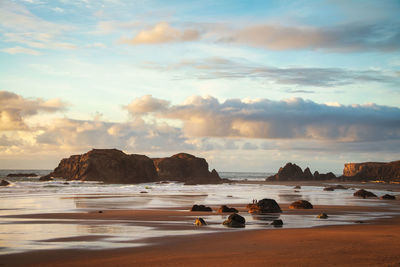 Scenic view of beach against sky during sunset