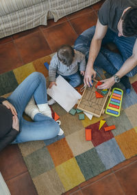 High angle view of parents playing with son while sitting at home