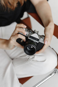 Midsection of woman holding camera