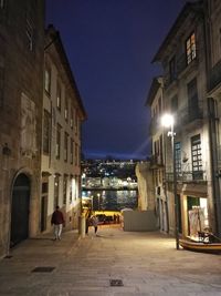 Illuminated city against sky at night