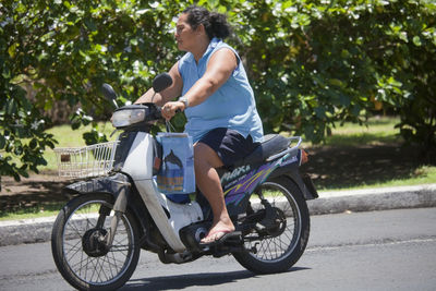 Full length of man riding motorcycle on road