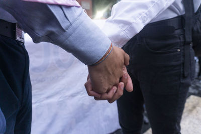 Midsection of people holding hands