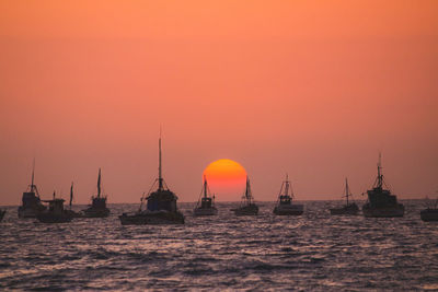 Silhouette of sailboats in sea during sunset