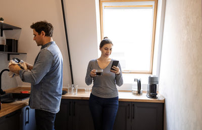 Side view of young woman standing at home