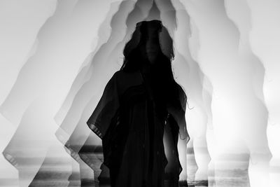 Rear view of woman standing against wall