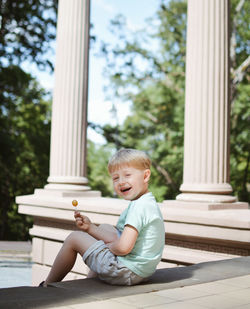 Boy playing with toy sitting outdoors