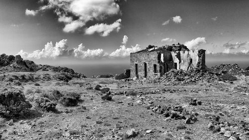 Abandoned built structure on landscape against sky