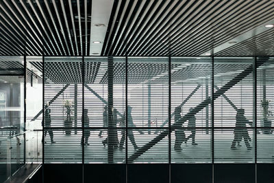 People walking in office seen from window