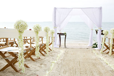 Chairs and table by entertainment tent at beach