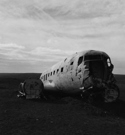 Abandoned airplane on runway against sky