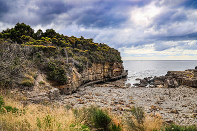 Rock formations by sea against sky