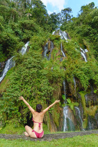 Full length of young woman jumping against mountain