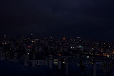 Illuminated cityscape against sky at night