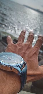 Close-up of hand on sea shore