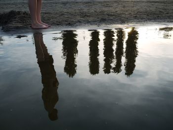 Low section of woman standing on puddle