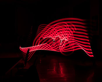 Close-up of illuminated red light against black background