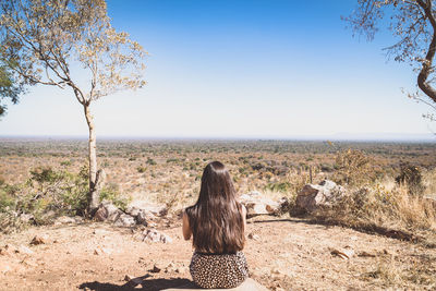 Rear view of woman looking at landscape against clear sky