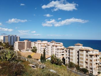 Buildings by sea against sky in city