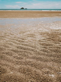 Close-up of sand on beach against sky