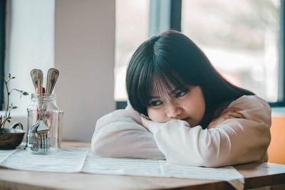 Portrait of girl leaning on table