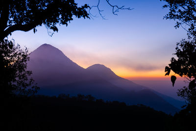 Low angle view of silhouette mountains against sky at sunset