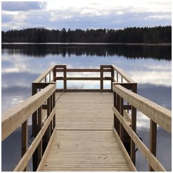 Wooden pier on lake against sky