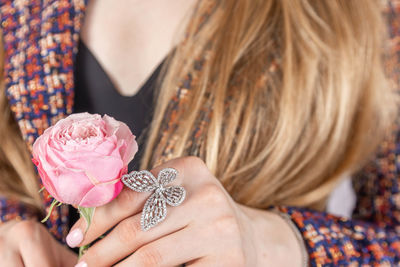 Close-up of woman's hand on tweed jacket holding flower