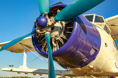 Low angle view of propeller airplane against clear blue sky