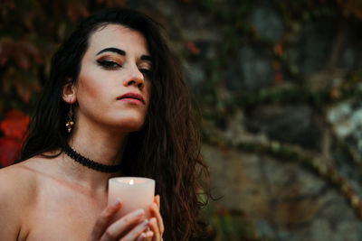 Portrait of a young woman drinking outdoors