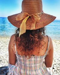 Rear view of woman wearing hat at beach