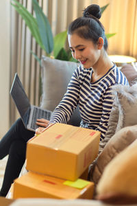 Side view of woman using digital tablet while sitting on table