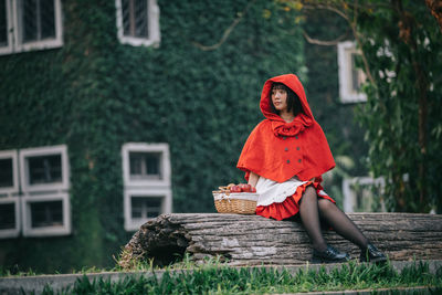 Woman holding red while sitting in basket