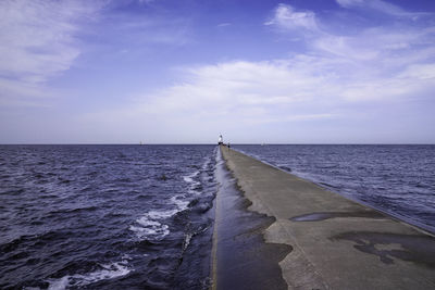 Scenic view of dam in ocean against sky